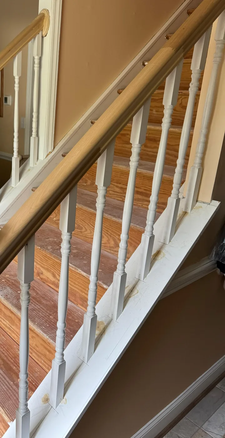 Remodeled staircase with oak rail and white balusters